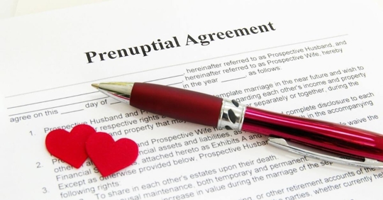 A pen resting on a document that reads "prenuptial agreement"