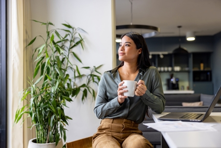 woman drinking coffee while looking out the window